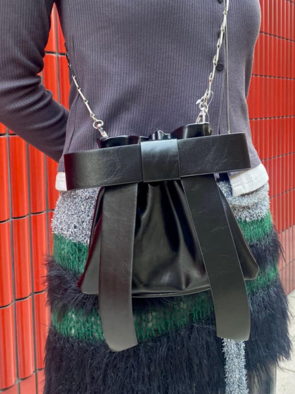 ブラック系のショルダーバッグ、グレー系のカーディガン/ボレロ、ブラック系のその他パンツを着用したレディースの秋コーディネートの3枚目の写真