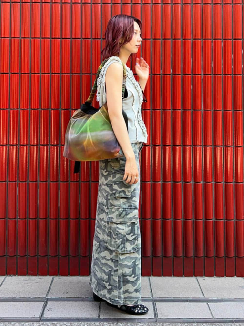 グリーン系のスカート、グレー系のベスト、その他のショルダーバッグを着用したレディースの夏コーディネートの2枚目の写真