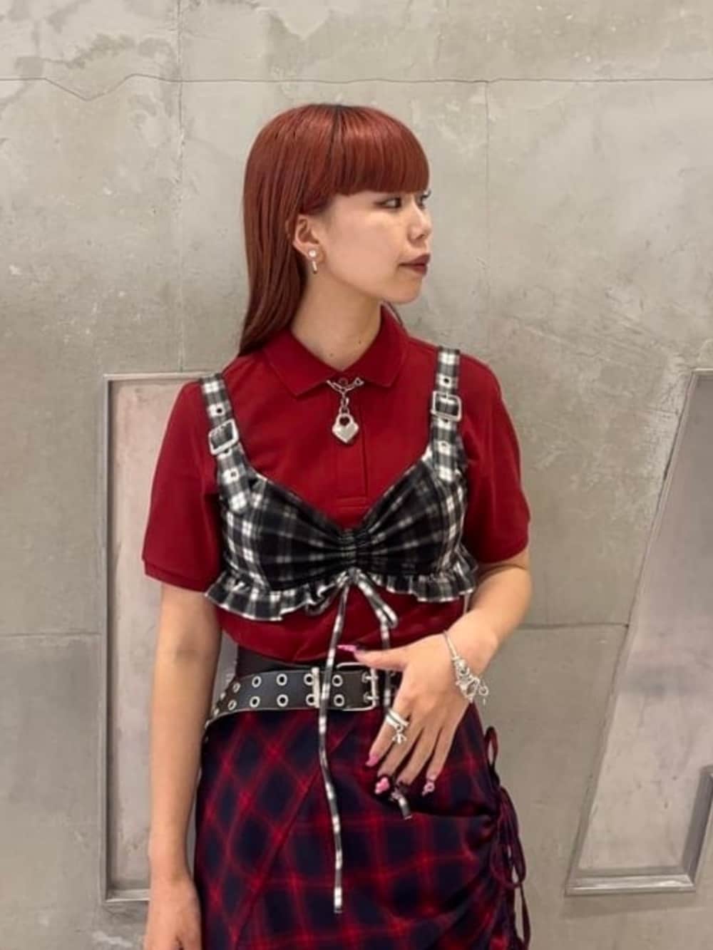 レッド系のスカート、レッド系のポロシャツを着用したレディースの夏コーディネートの2枚目の写真