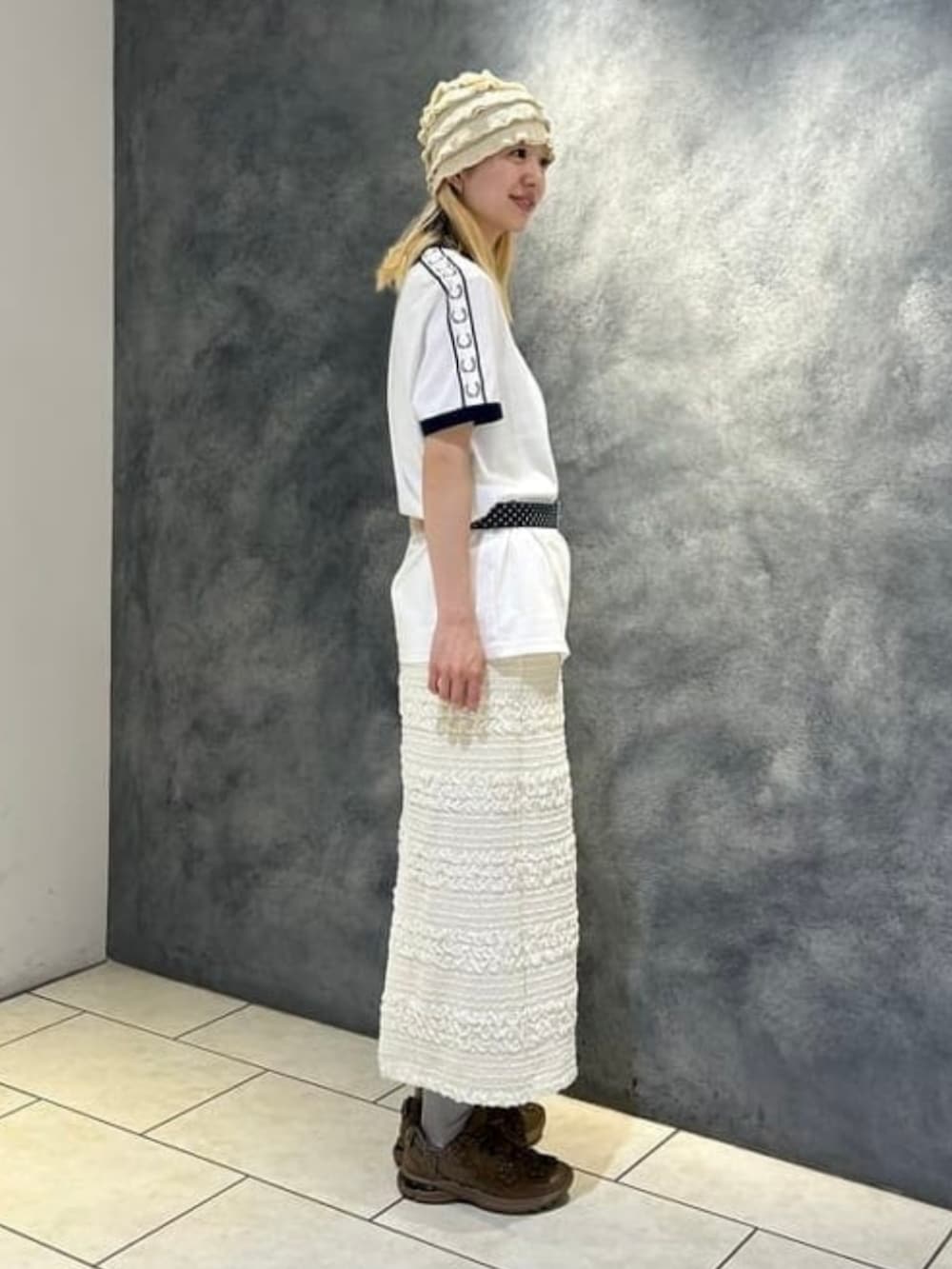 ホワイト系のスカート、ホワイト系のTシャツ/カットソー、ブラウン系のベルトを着用したレディースの夏コーディネートの2枚目の写真