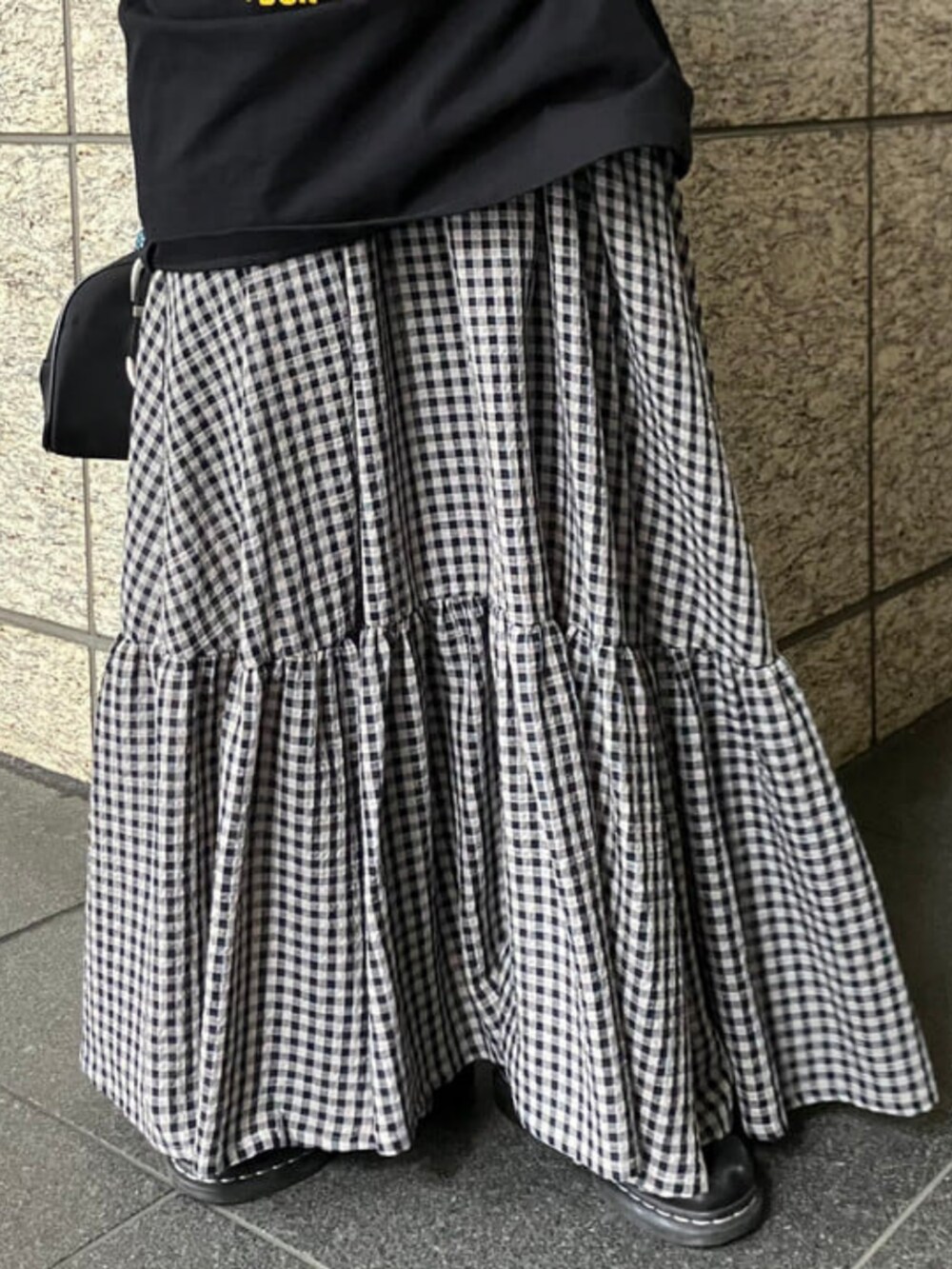 ブラック系のボストンバッグ、ブラック系のワンピース、ブルー系のポーチを着用したレディースの春コーディネートの2枚目の写真