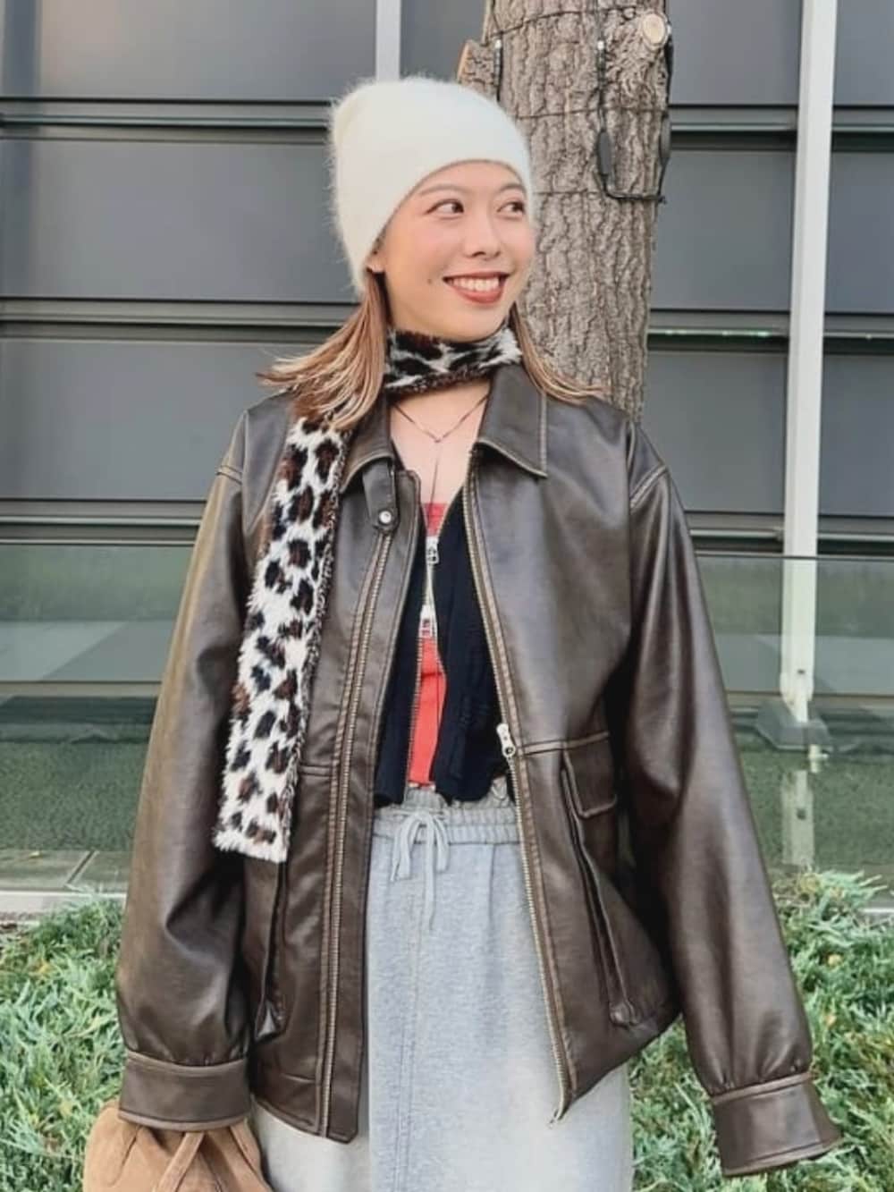 ブラウン系のブルゾン、ブラック系のカーディガン/ボレロ、ブラウン系のマフラーを着用したレディースの冬コーディネートの2枚目の写真