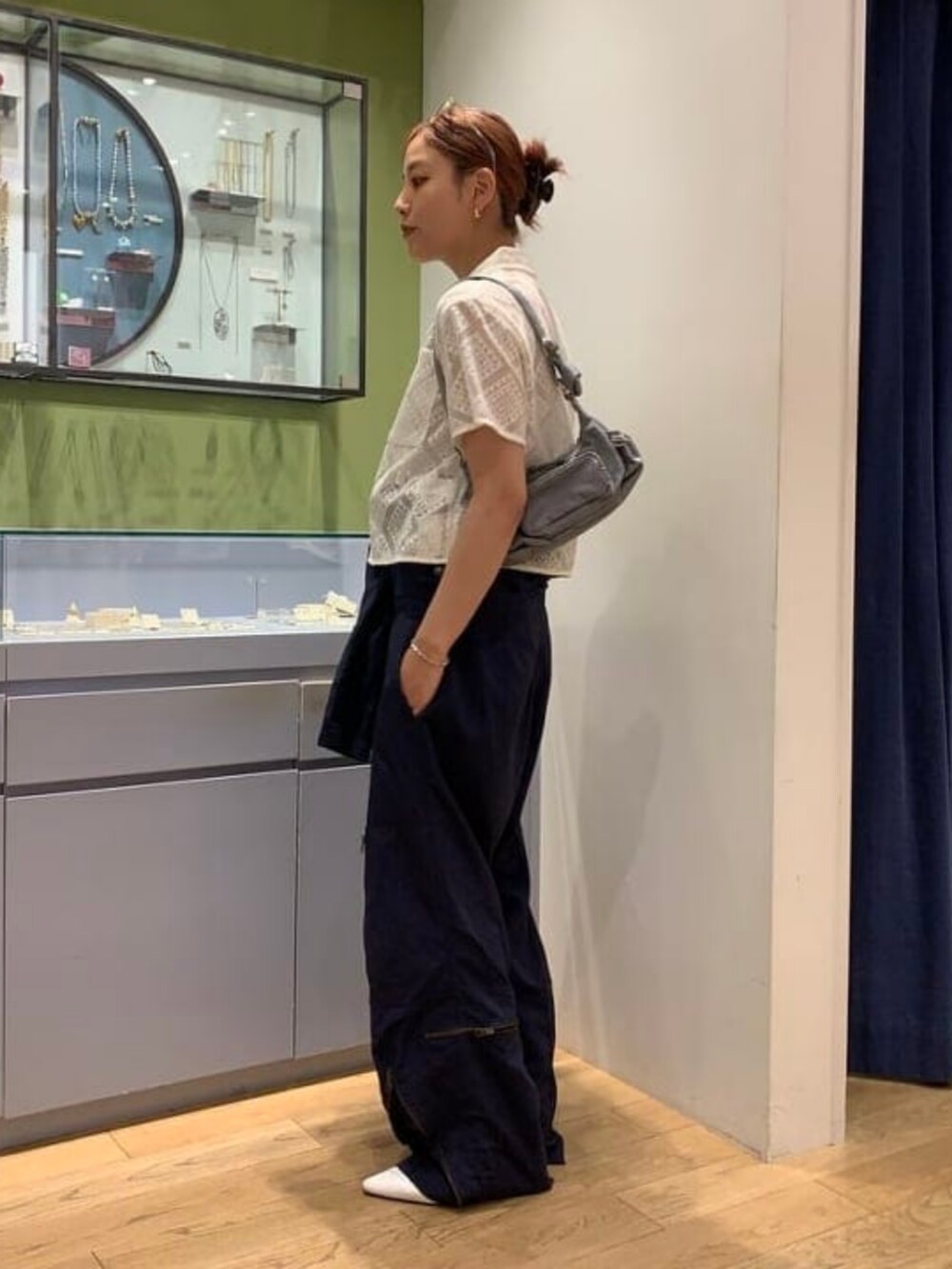 グレー系のトートバッグ、ホワイト系のシャツ/ブラウスを着用したレディースの夏コーディネートの2枚目の写真