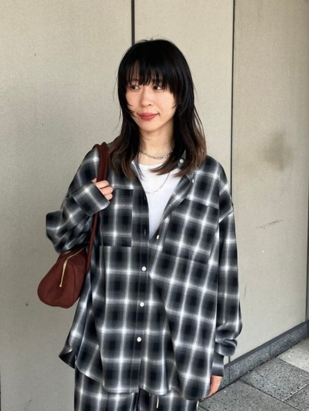 ブラウン系のトートバッグ、ブラック系のその他パンツ、ブラック系のシャツ/ブラウスを着用したレディースの秋コーディネートの3枚目の写真