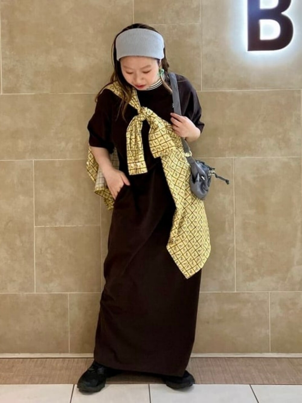 グレー系のトートバッグ、ブラウン系のワンピース、グレー系のその他小物を着用したレディースの春コーディネートの2枚目の写真