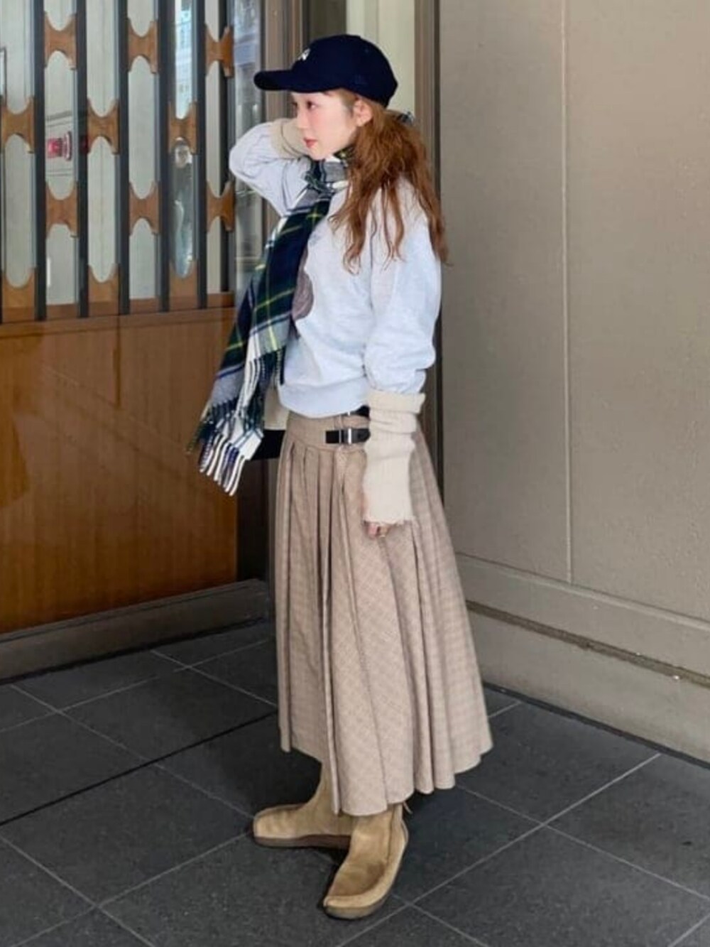 ベージュ系のスカート、ブラウン系のスウェット、グリーン系のマフラーを着用したレディースの秋コーディネートの2枚目の写真