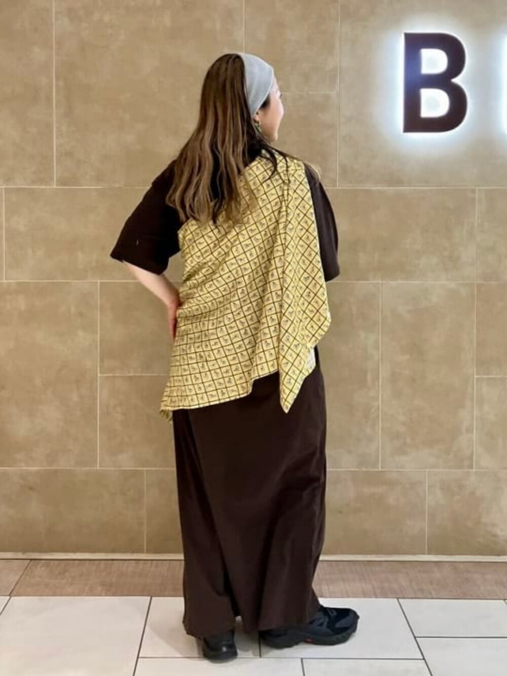 グレー系のトートバッグ、ブラウン系のワンピース、グレー系のその他小物を着用したレディースの春コーディネートの3枚目の写真