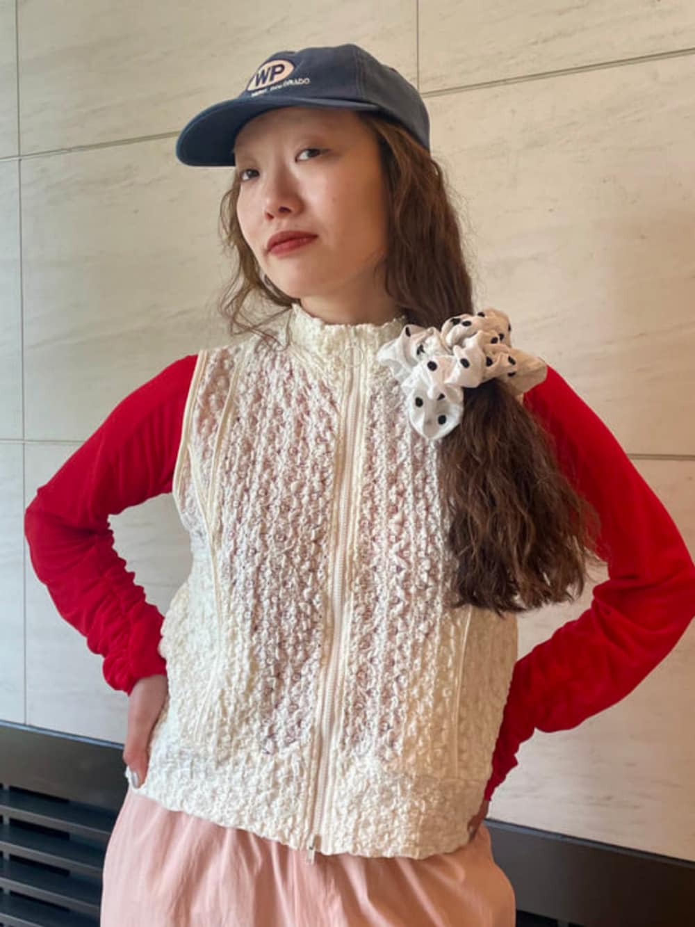 レッド系のカーディガン/ボレロ、ピンク系のカーゴパンツ、ホワイト系のベストを着用したレディースの春コーディネートの2枚目の写真