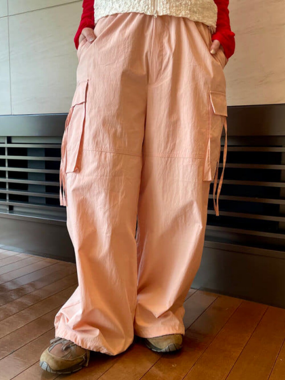 レッド系のカーディガン/ボレロ、ピンク系のカーゴパンツ、ホワイト系のベストを着用したレディースの春コーディネートの3枚目の写真