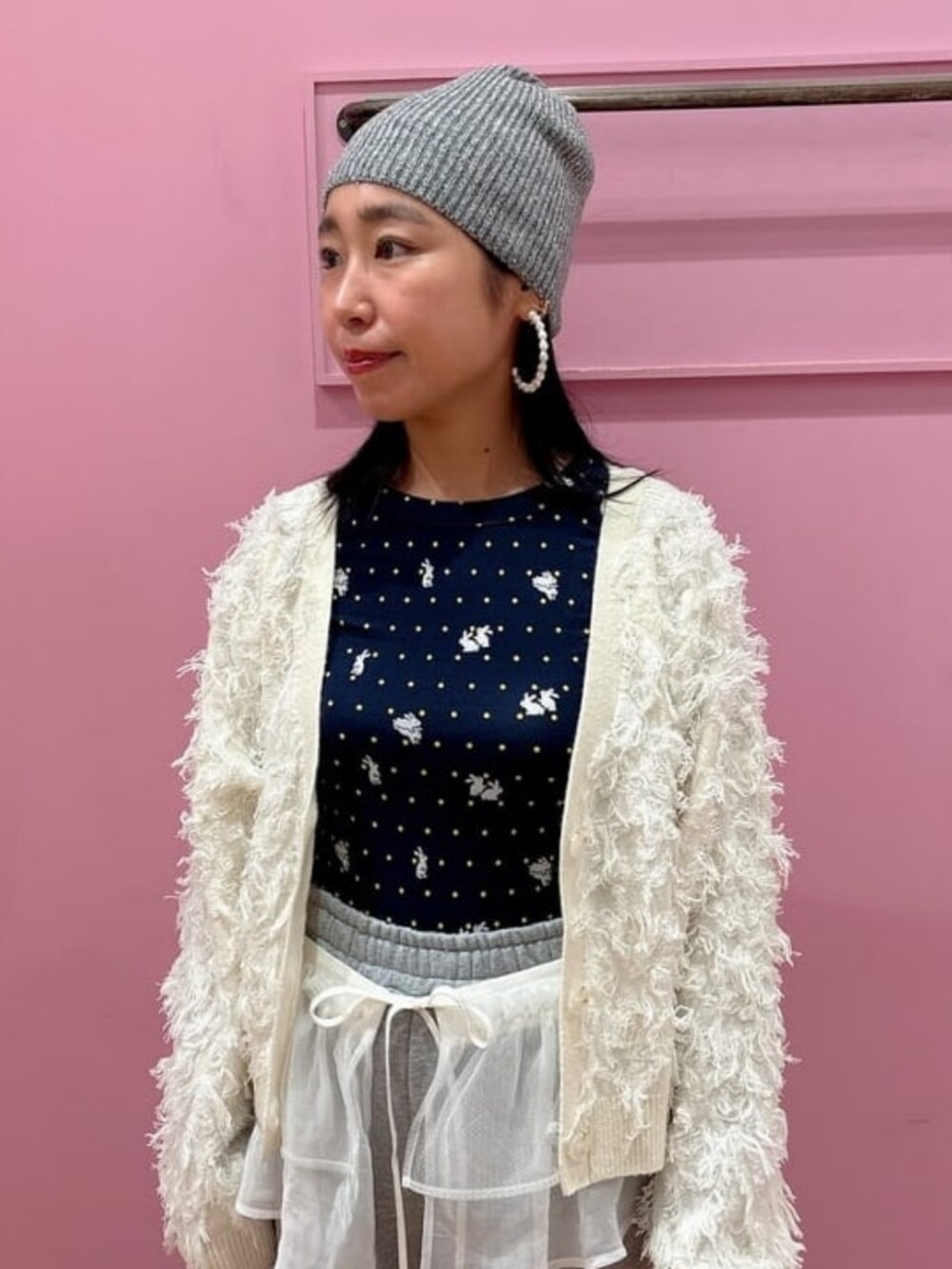 シルバー系のスウェットパンツ、ホワイト系のカーディガン/ボレロ、グレー系のニットキャップ/ビーニーを着用したレディースの秋コーディネートの2枚目の写真