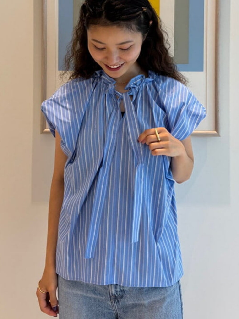 ブラック系のトートバッグ、ブルー系のシャツ/ブラウス、ブルー系のデニムパンツを着用したレディースの夏コーディネートの2枚目の写真