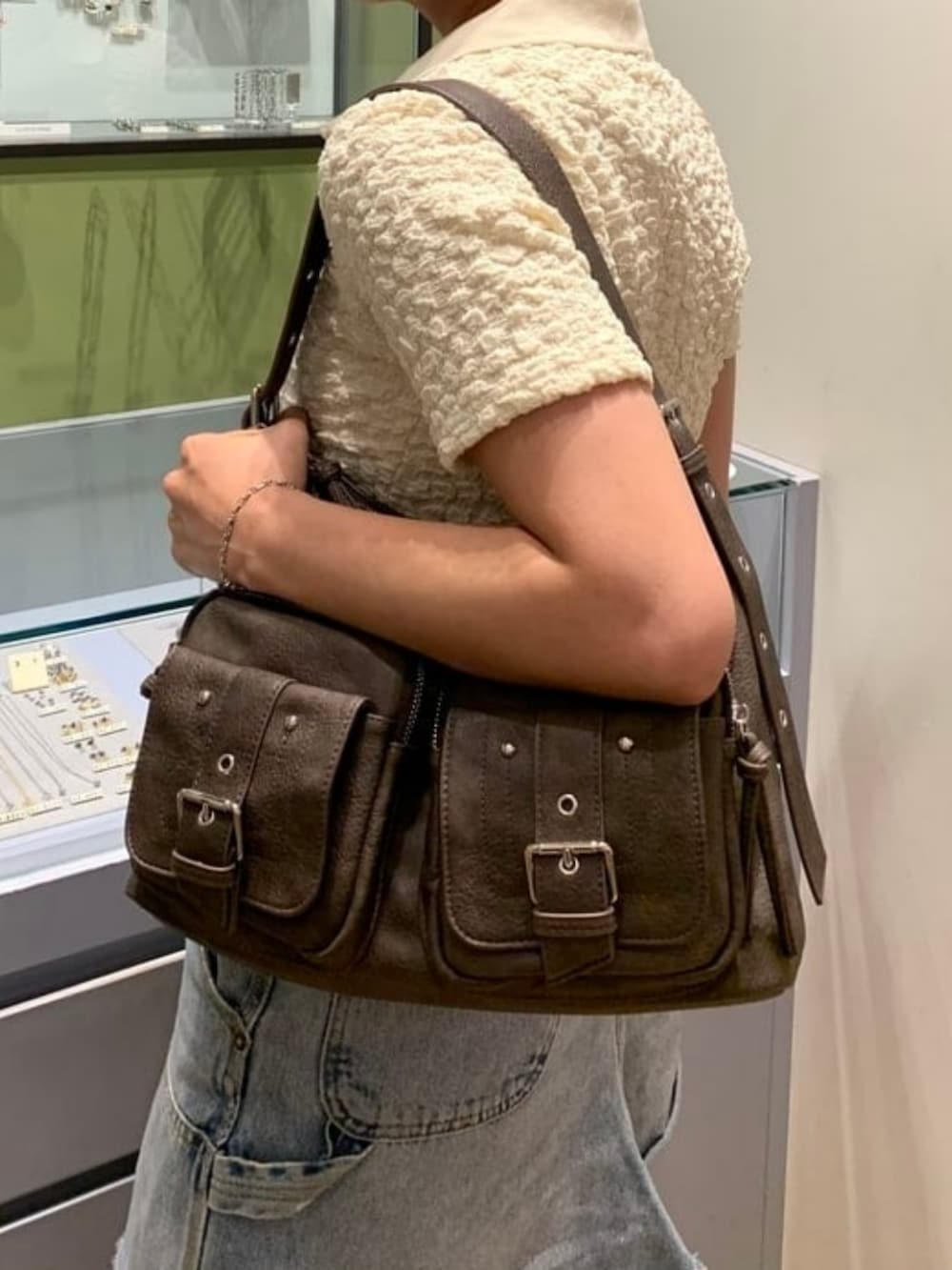 ブラウン系のトートバッグ、ホワイト系のTシャツ/カットソー、ブラウン系のブーツを着用したレディースの春コーディネートの3枚目の写真