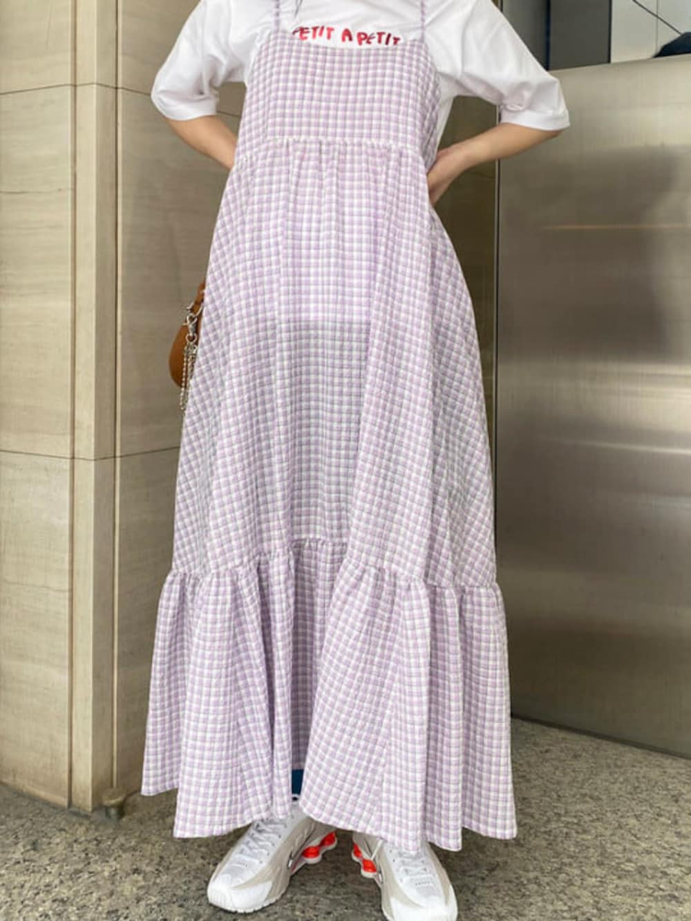 ブラウン系のトートバッグ、パープル系のワンピース、ホワイト系のスニーカーを着用したレディースの夏コーディネートの3枚目の写真