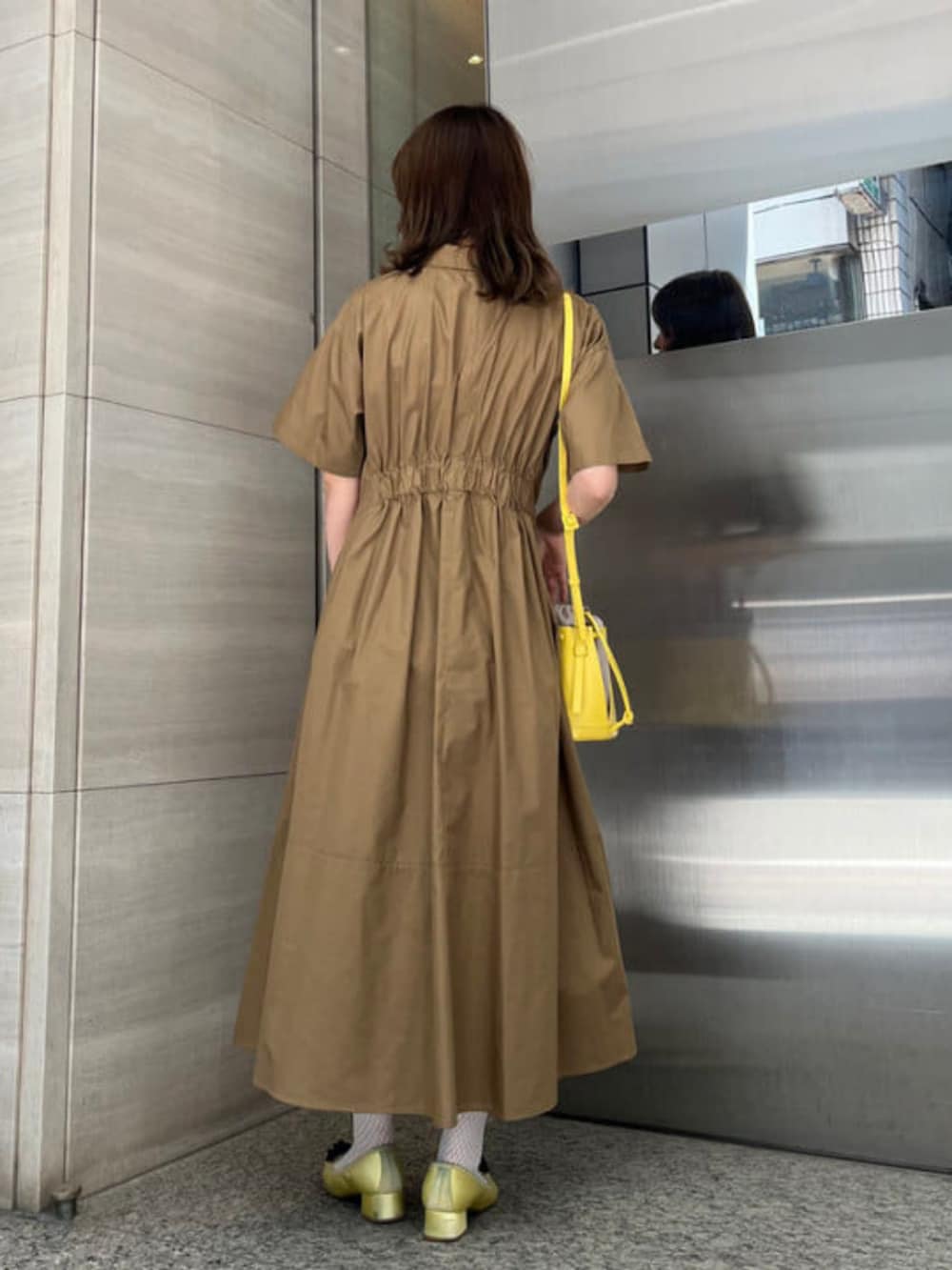 ブラウン系のワンピース、ブラック系のショルダーバッグを着用したレディースの夏コーディネートの3枚目の写真