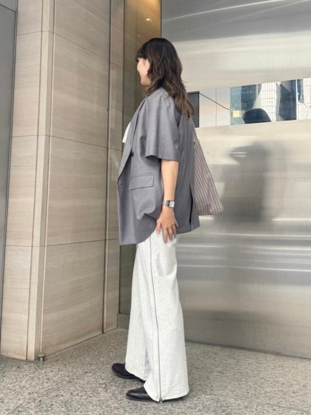 ベージュ系のスウェットパンツ、ホワイト系のシャツ/ブラウス、グレー系のテーラードジャケットを着用したレディースの春コーディネートの2枚目の写真