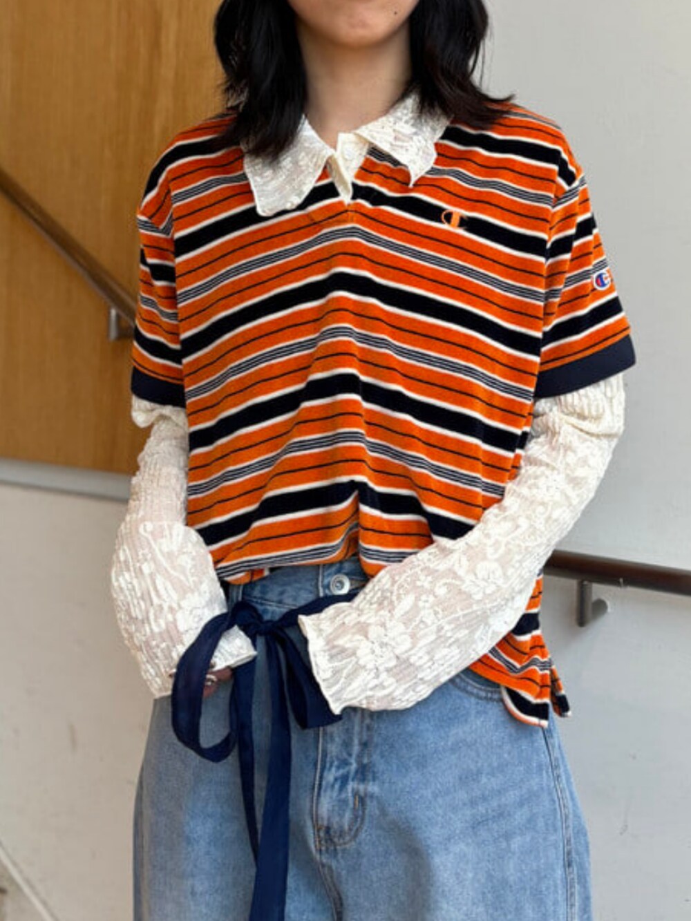 ホワイト系のシャツ/ブラウス、ブルー系のデニムパンツ、オレンジ系のポロシャツを着用したレディースの春コーディネートの3枚目の写真