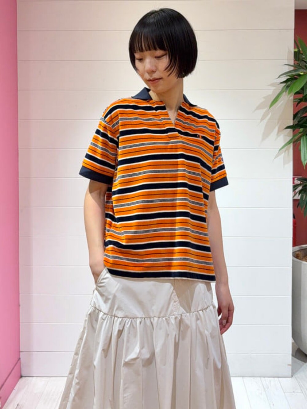 ホワイト系のデニムパンツ、ホワイト系のスカート、ブラック系のトートバッグを着用したレディースの春コーディネートの2枚目の写真