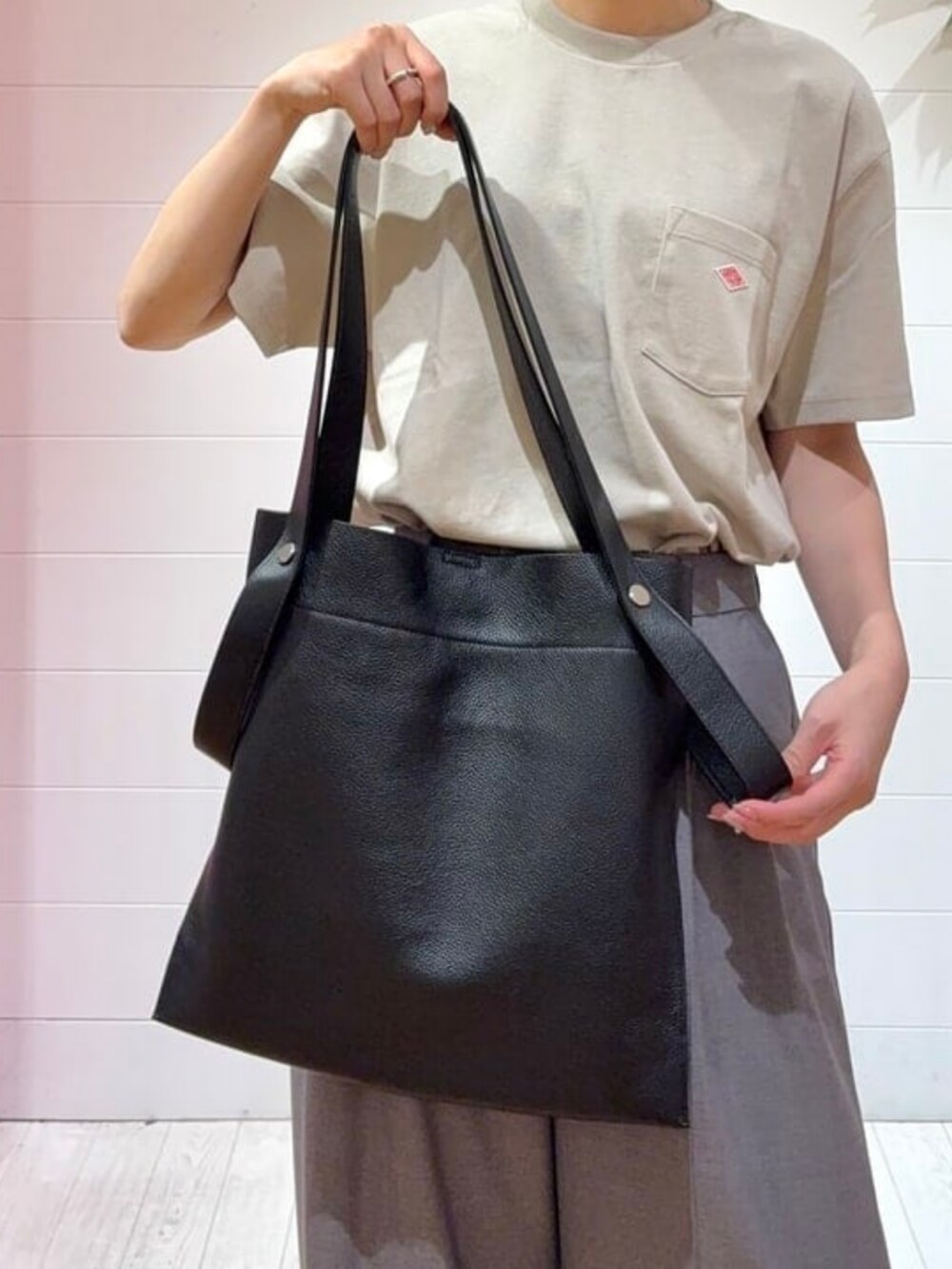 ブラック系のトートバッグ、ブラック系のサンダル、ベージュ系のTシャツ/カットソーを着用したレディースの夏コーディネートの4枚目の写真