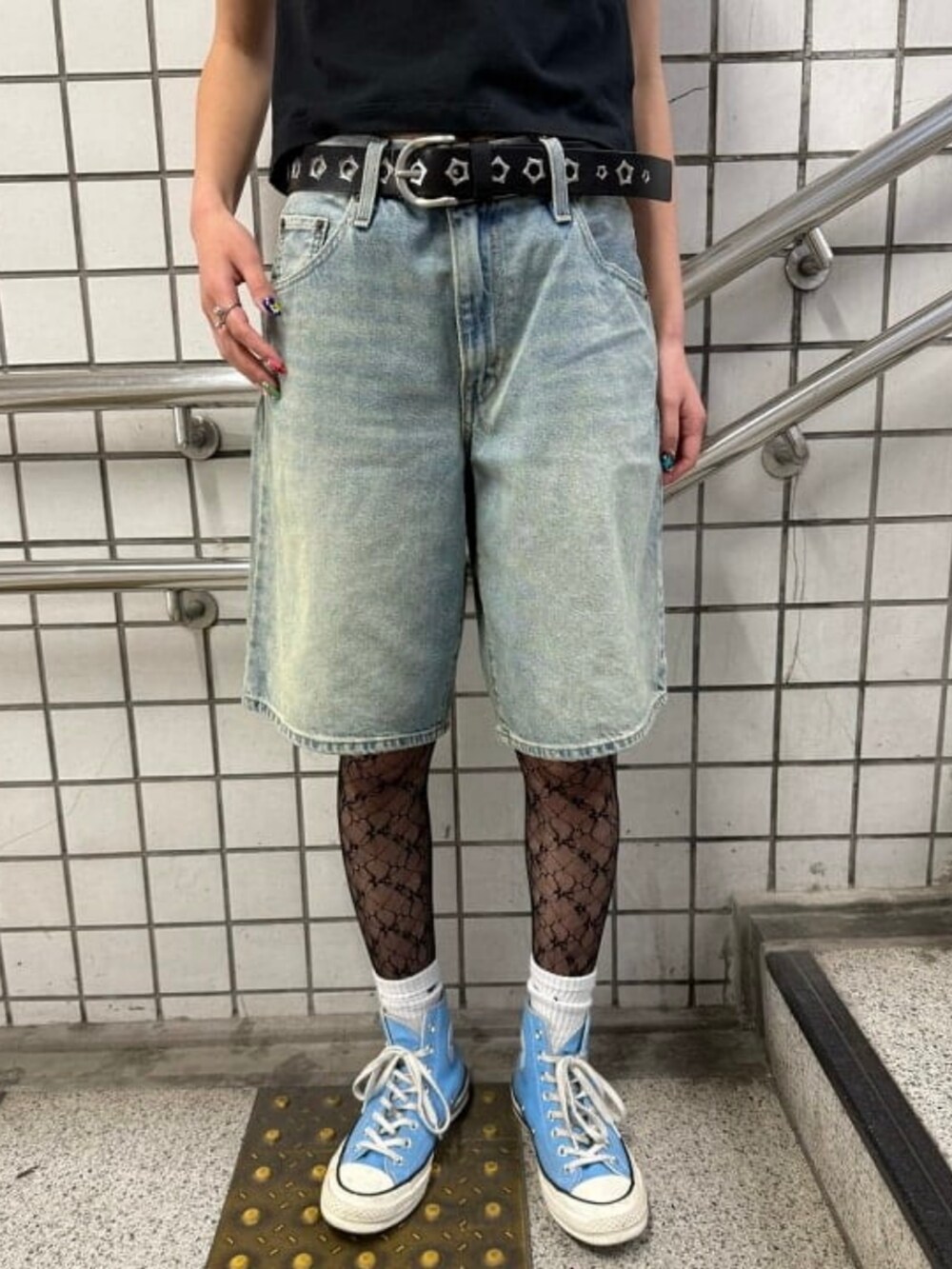 ブルー系のデニムパンツ、ブラック系のTシャツ/カットソー、ブラック系のタイツ/ストッキングを着用したレディースの春コーディネートの2枚目の写真