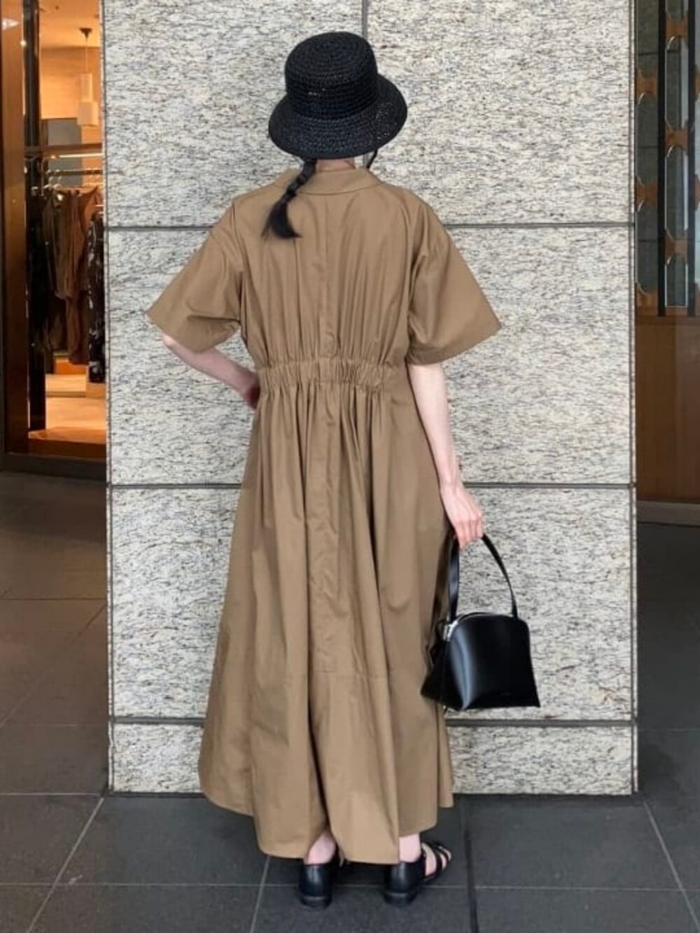 ブラウン系のワンピース、ブラック系のトートバッグ、ブラック系のハットを着用したレディースの夏コーディネートの2枚目の写真