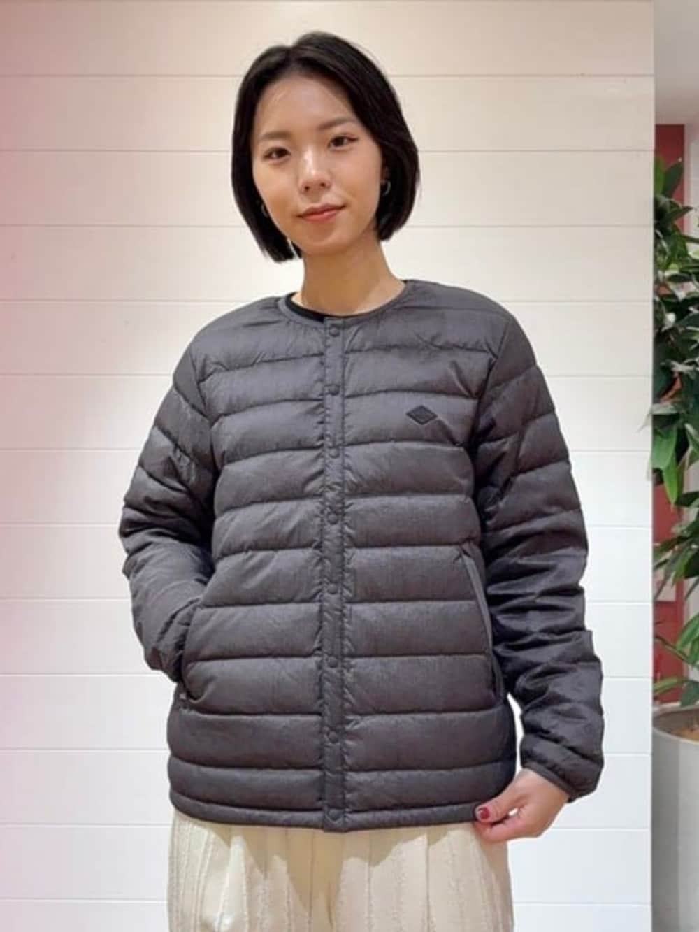 グリーン系のトートバッグ、ホワイト系のその他パンツ、ブラック系のダウンジャケット/コートを着用したレディースの秋コーディネートの2枚目の写真