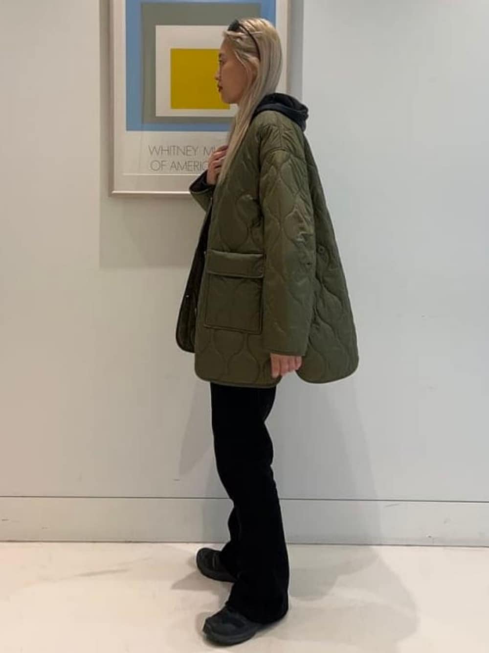 グリーン系のブルゾン、ブラック系のその他パンツ、グレー系のパーカーを着用したレディースの冬コーディネートの2枚目の写真