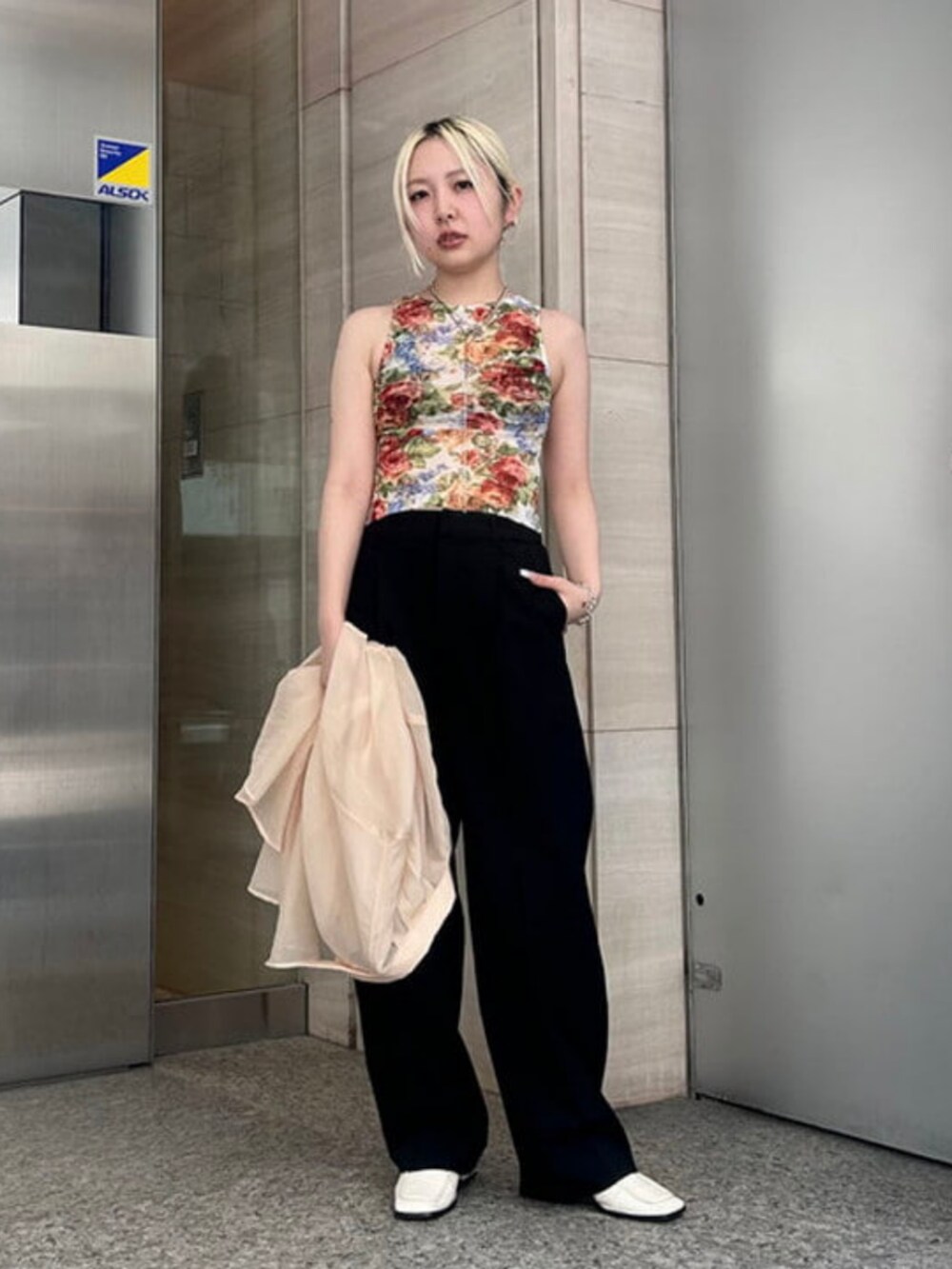 ベージュ系のシャツ/ブラウス、ブラック系のスラックスを着用したレディースの夏コーディネートの2枚目の写真