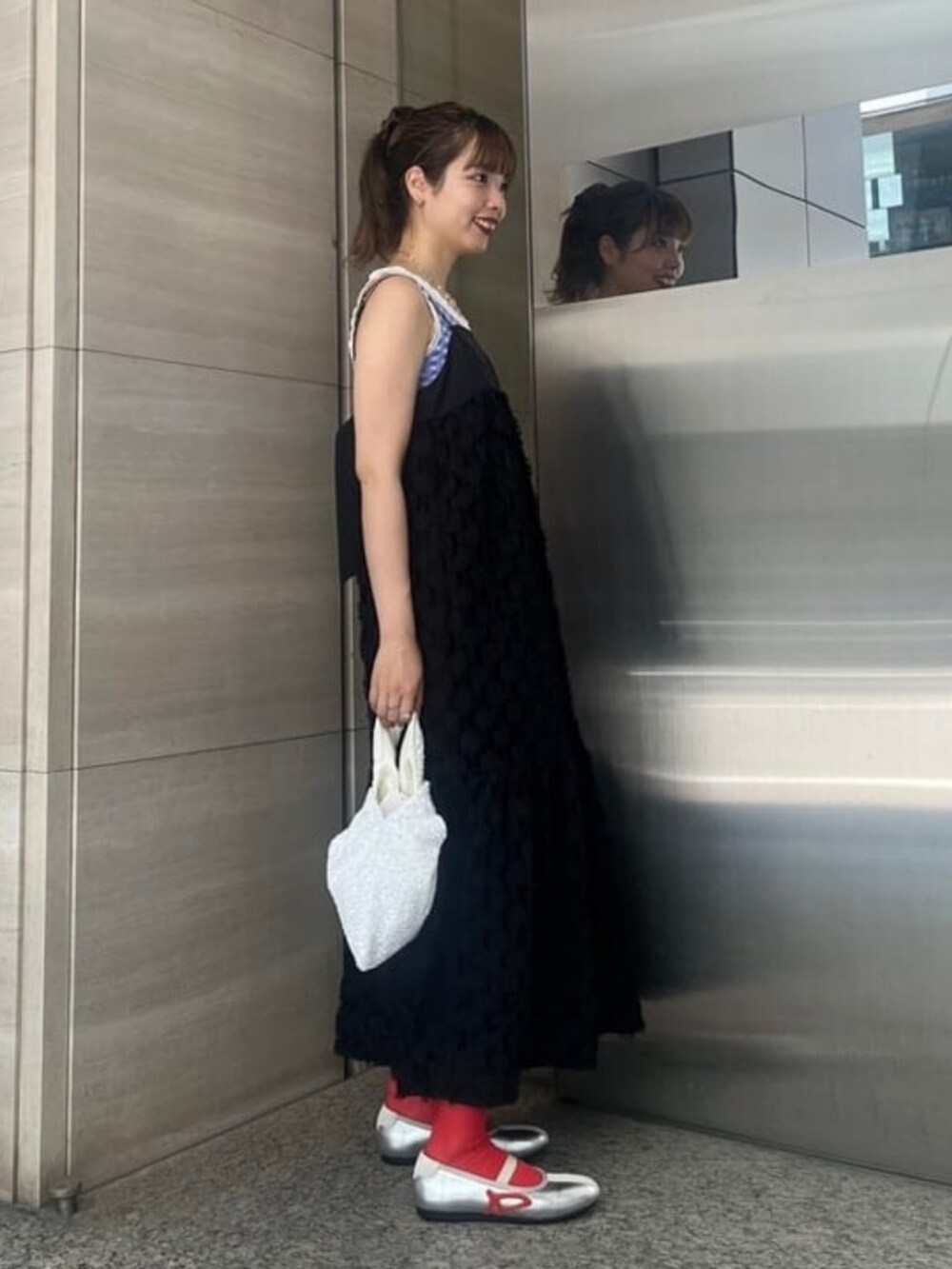 ブラック系のワンピース、シルバー系のスニーカー、ホワイト系のトートバッグを着用したレディースの夏コーディネートの2枚目の写真