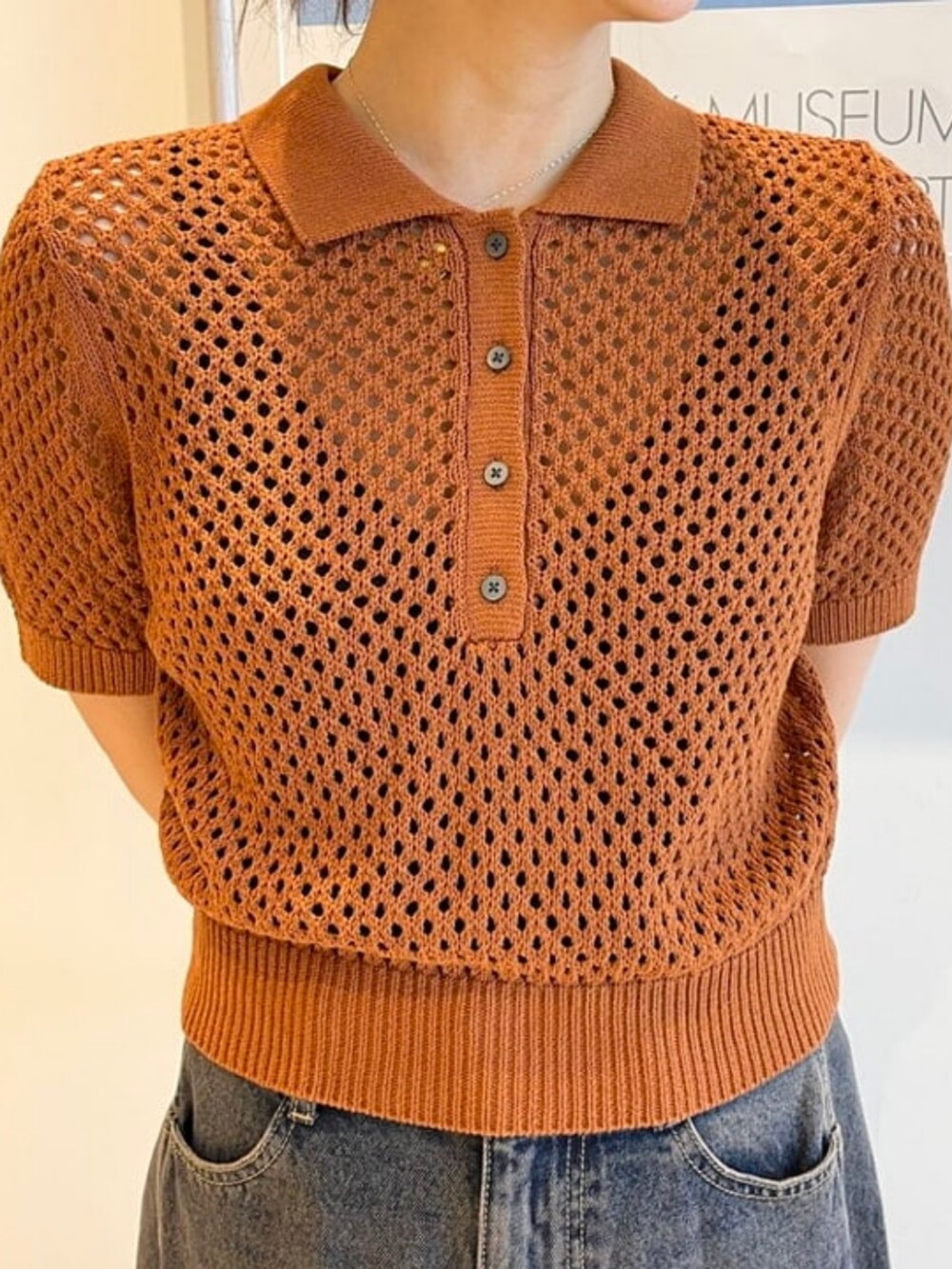 ブラウン系のポロシャツ、ブルー系のデニムパンツを着用したレディースの春コーディネートの2枚目の写真