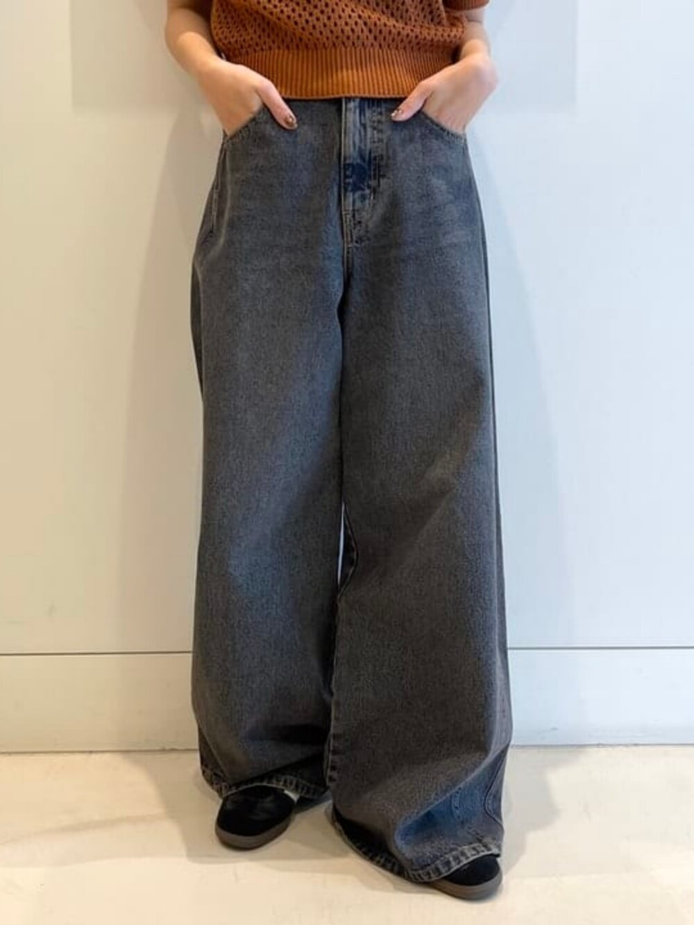 ブラウン系のポロシャツ、ブルー系のデニムパンツを着用したレディースの春コーディネートの3枚目の写真