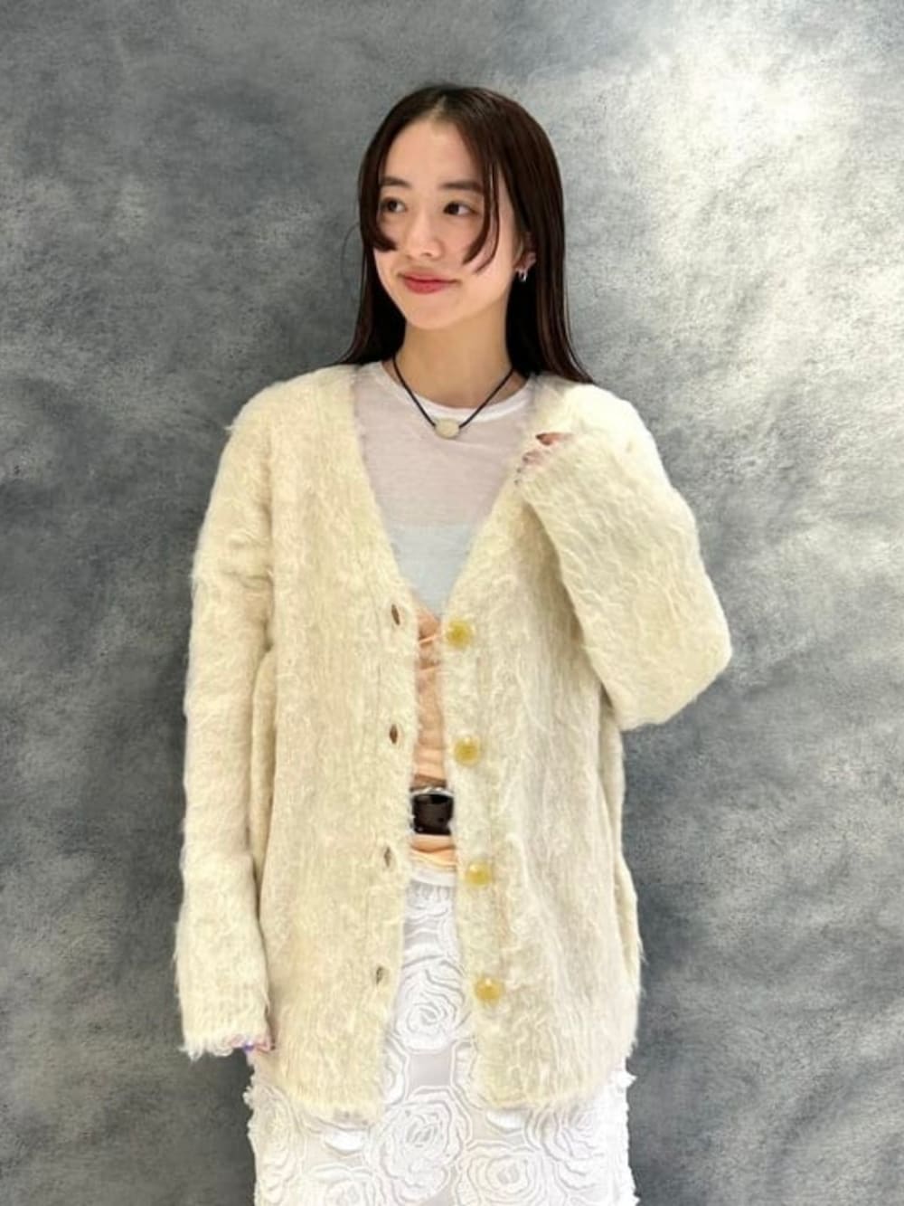 ブラック系のトートバッグ、ブラウン系のブルゾン、ホワイト系のカーディガン/ボレロを着用したレディースの冬コーディネートの2枚目の写真