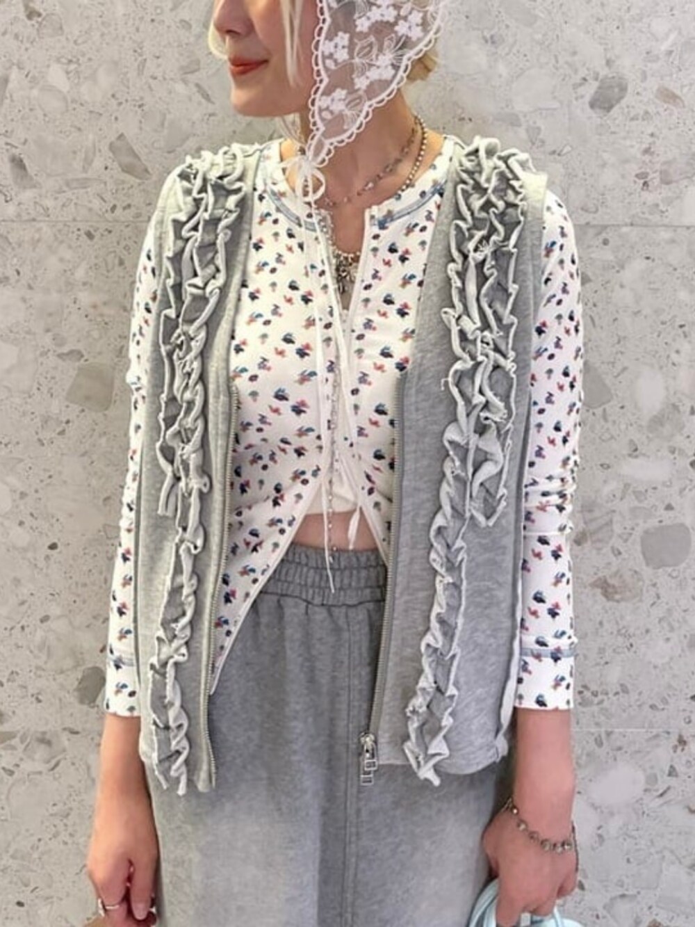 グレー系のスカート、グレー系のベストを着用したレディースの夏コーディネートの2枚目の写真