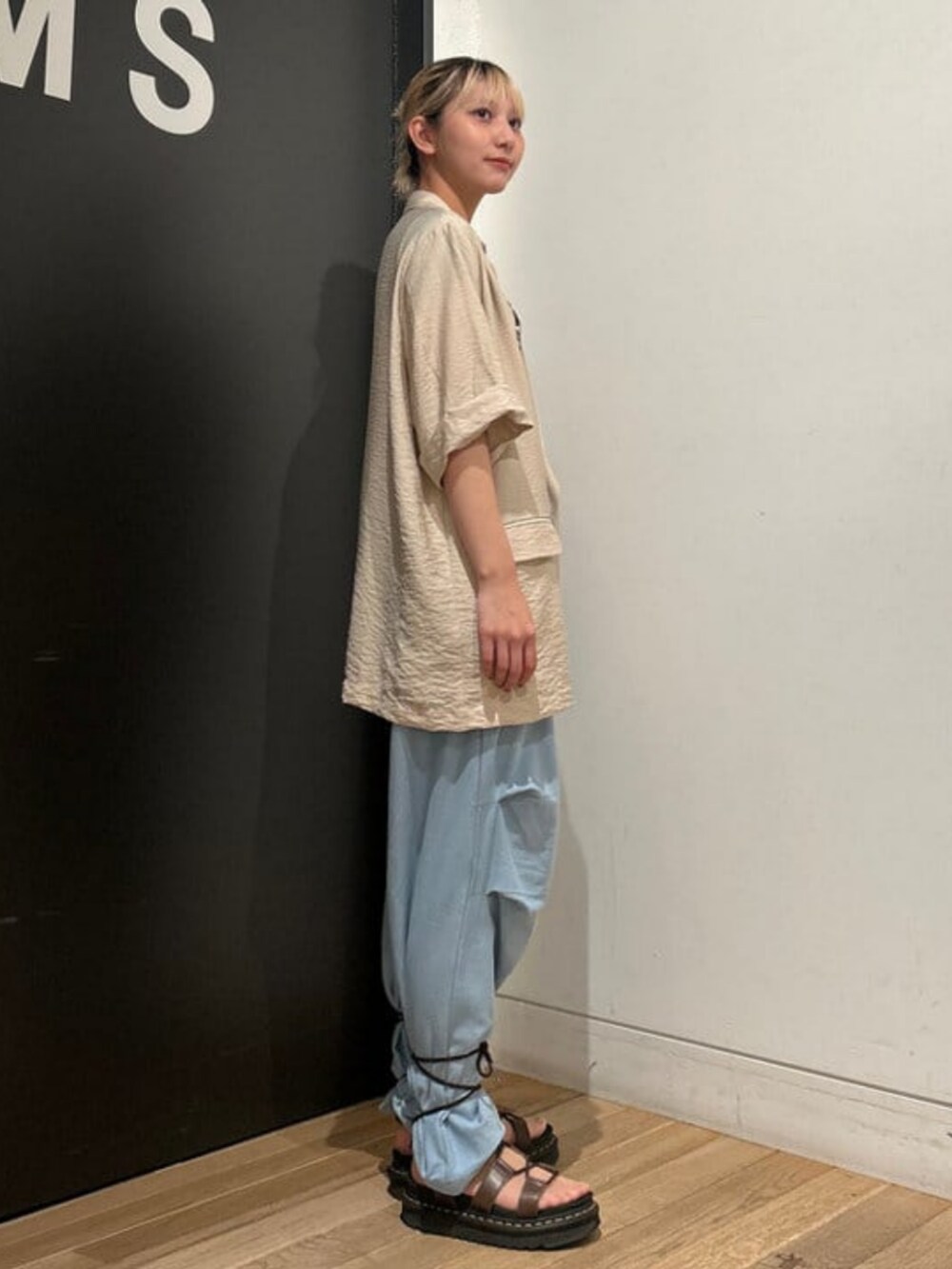 ブルー系のスウェットパンツ、ベージュ系のテーラードジャケット、ベージュ系のTシャツ/カットソーを着用したレディースの春コーディネートの2枚目の写真