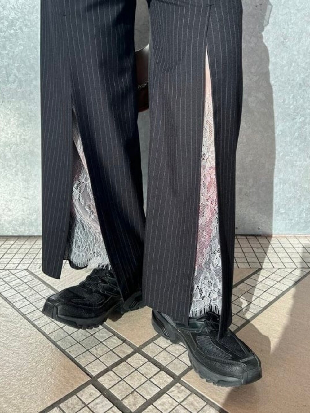 ブラウン系のトートバッグ、ブルー系のスラックス、ブラウン系のTシャツ/カットソーを着用したレディースの春コーディネートの4枚目の写真