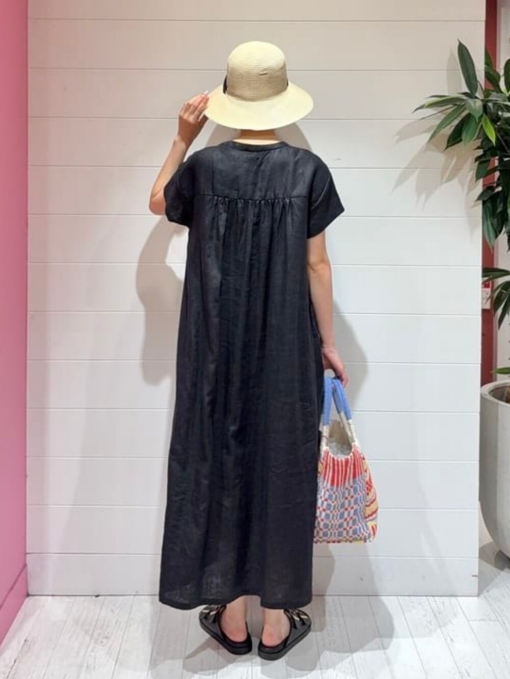 ブラック系のワンピース、ブルー系のかごバッグ、ブラック系のサンダルを着用したレディースの夏コーディネートの3枚目の写真