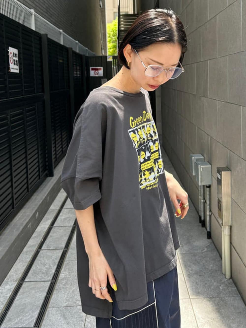 ブルー系のスカート、ブラック系のTシャツ/カットソー、シルバー系のメガネを着用したレディースの春コーディネートの2枚目の写真