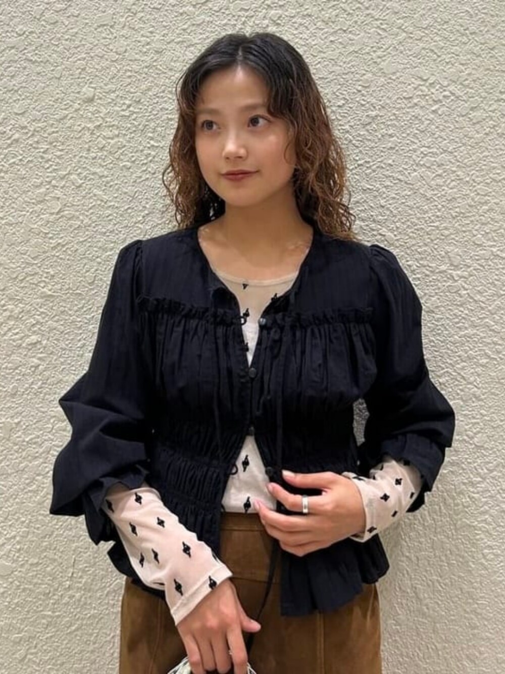 ベージュ系のTシャツ/カットソー、ブラック系のシャツ/ブラウス、ブラウン系のスカートを着用したレディースの秋コーディネートの2枚目の写真