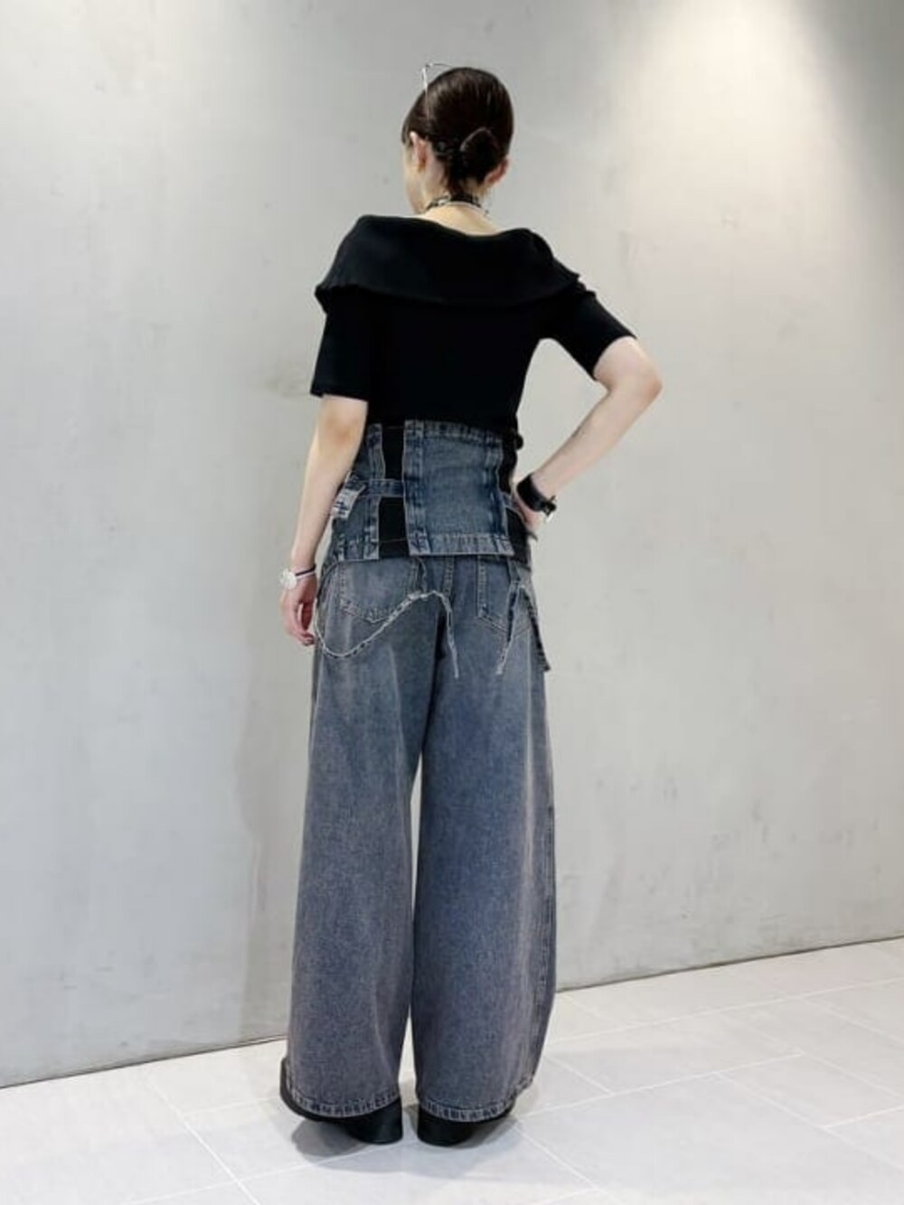 ブルー系のデニムパンツ、ブルー系のキャミソール、ブラック系のTシャツ/カットソーを着用したレディースの春コーディネートの2枚目の写真