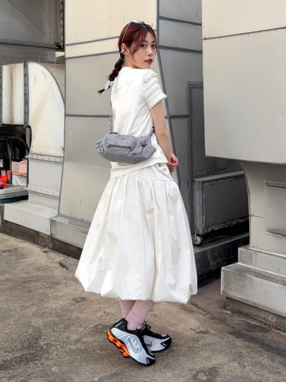 ホワイト系のスカート、グレー系のトートバッグ、ホワイト系のTシャツ/カットソーを着用したレディースの夏コーディネートの2枚目の写真