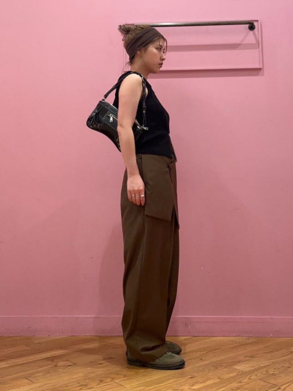 ブラック系のショルダーバッグ、ブラック系のベスト、ブラウン系のその他パンツを着用したレディースの夏コーディネートの2枚目の写真