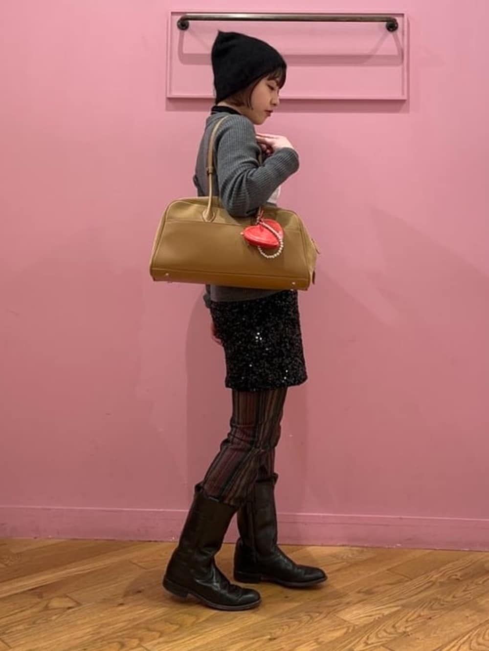 シルバー系のカーディガン/ボレロ、ベージュ系のボストンバッグ、ブラック系のニットキャップ/ビーニーを着用したレディースの冬コーディネートの2枚目の写真