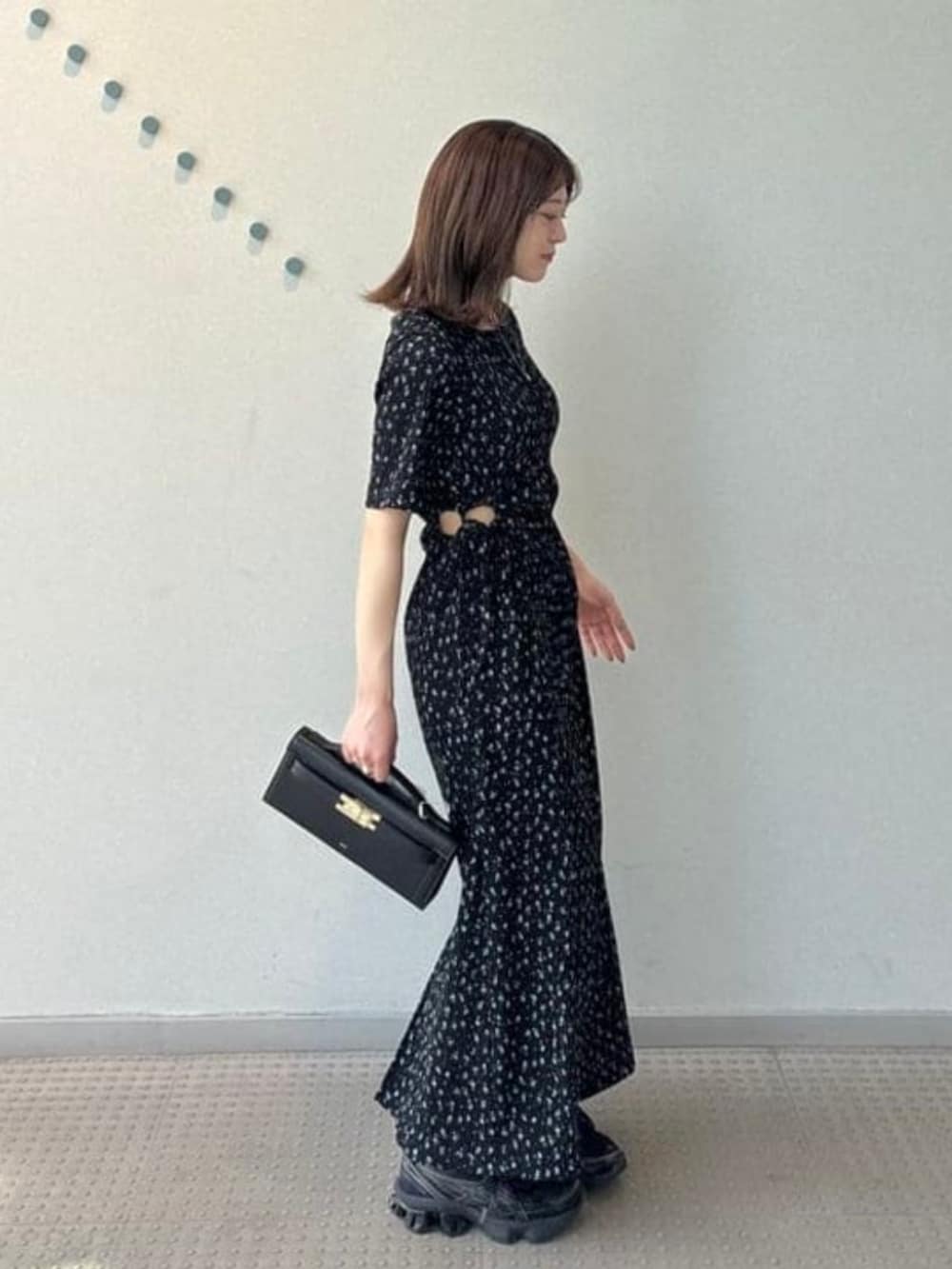 グレー系のテーラードジャケット、ブラック系のワンピース、グレー系のスニーカーを着用したレディースの春コーディネートの2枚目の写真