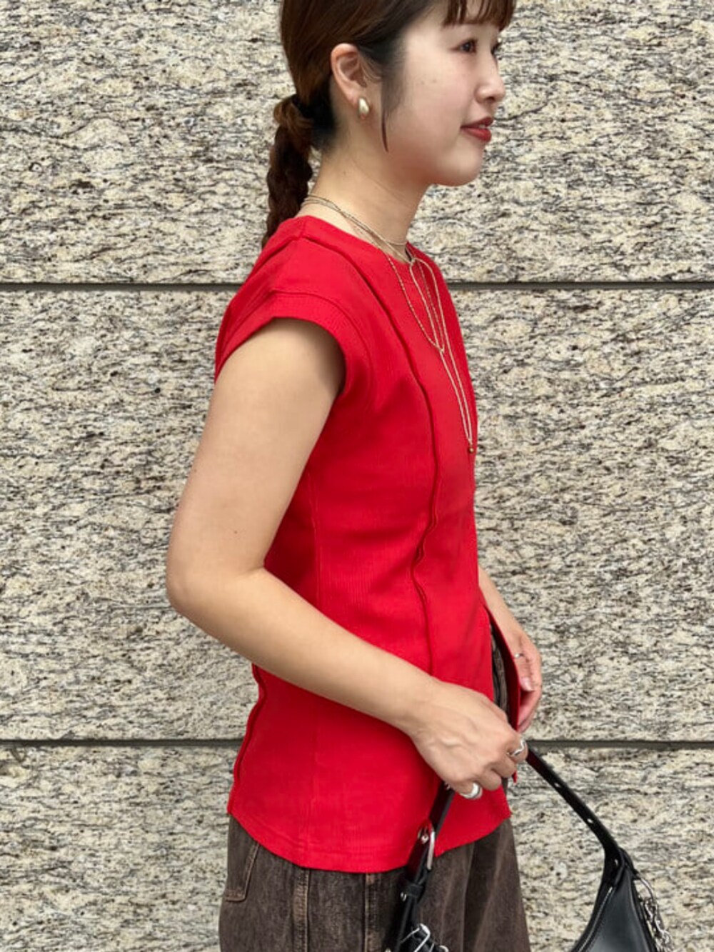 ブラック系のトートバッグ、ブラウン系のデニムパンツ、レッド系のTシャツ/カットソーを着用したレディースの夏コーディネートの2枚目の写真