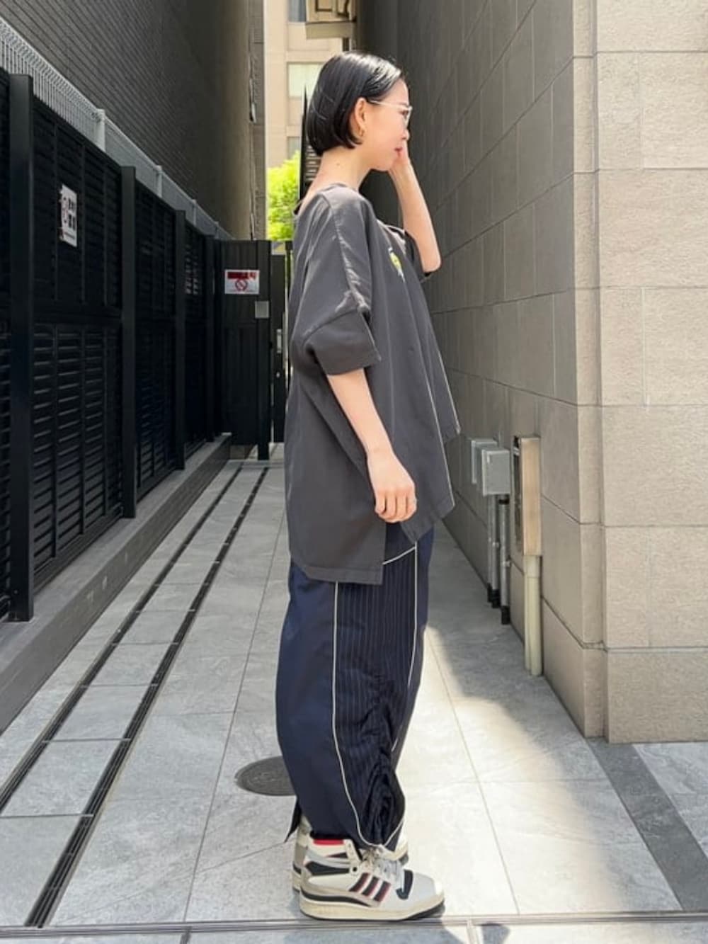 ブルー系のスカート、ブラック系のTシャツ/カットソー、シルバー系のメガネを着用したレディースの春コーディネートの3枚目の写真