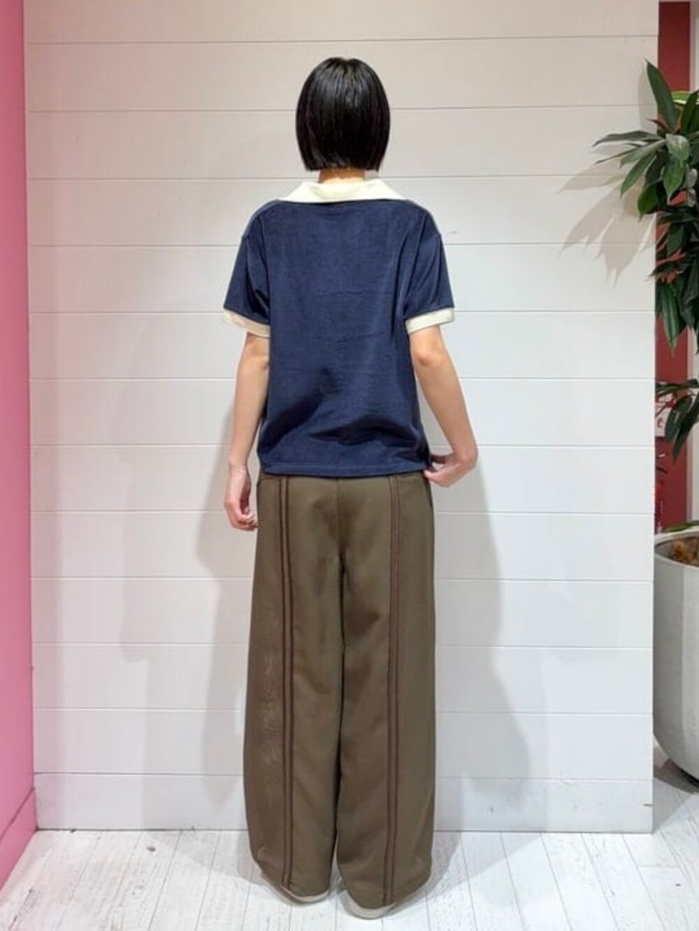 ブルー系のポロシャツ、ブラウン系のその他パンツを着用したレディースの夏コーディネートの2枚目の写真