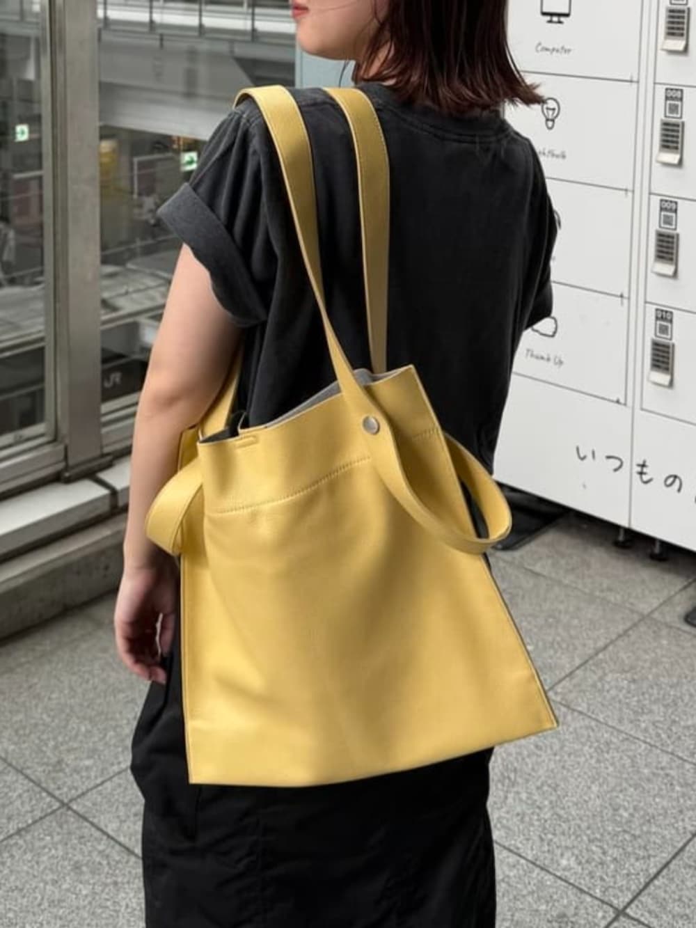 ベージュ系のトートバッグ、ブラック系のTシャツ/カットソー、ブラック系のスカートを着用したレディースの春コーディネートの2枚目の写真