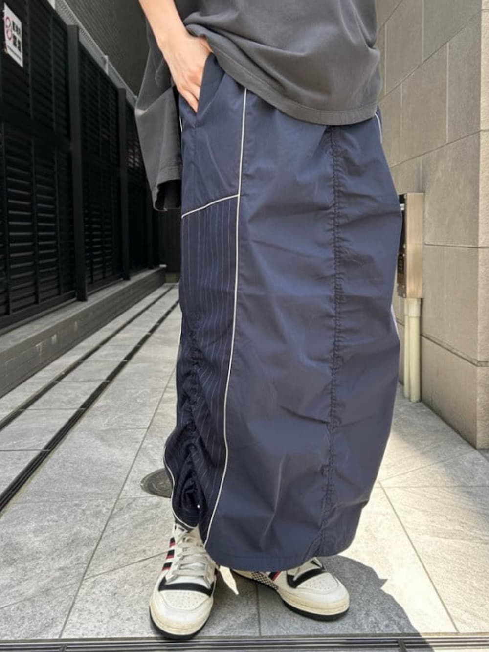 ブルー系のスカート、ブラック系のTシャツ/カットソー、シルバー系のメガネを着用したレディースの春コーディネートの4枚目の写真