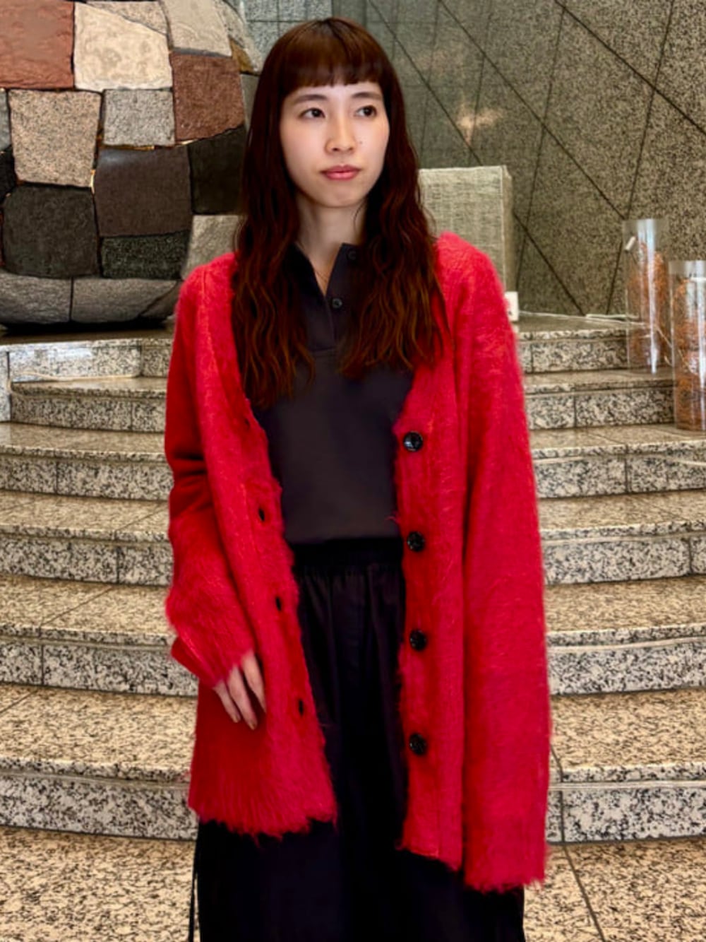 レッド系のカーディガン/ボレロ、ブラック系のカーゴパンツを着用したレディースの冬コーディネートの2枚目の写真