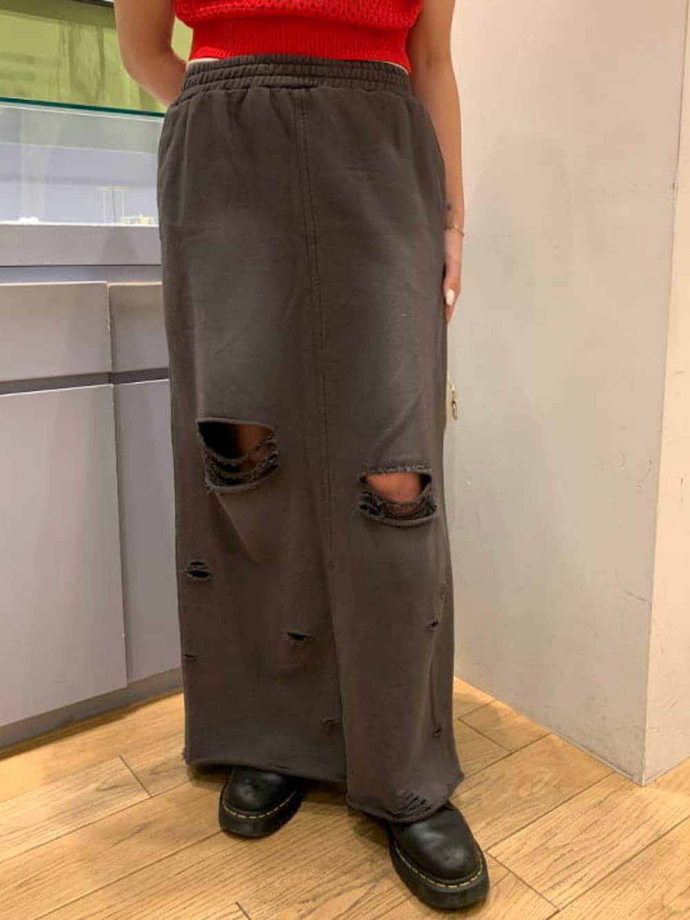 ホワイト系のトートバッグ、グレー系のスカート、レッド系のポロシャツを着用したレディースの春コーディネートの3枚目の写真