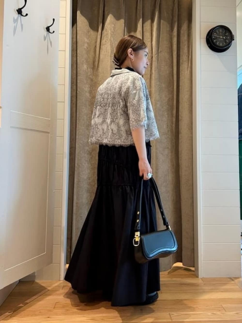 ブラック系のハンドバッグ、ブルー系のシャツ/ブラウス、ブラック系のワンピースを着用したレディースの春コーディネートの3枚目の写真